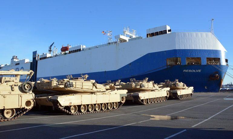 Military vehicles staged beside a RoRo cargo ship