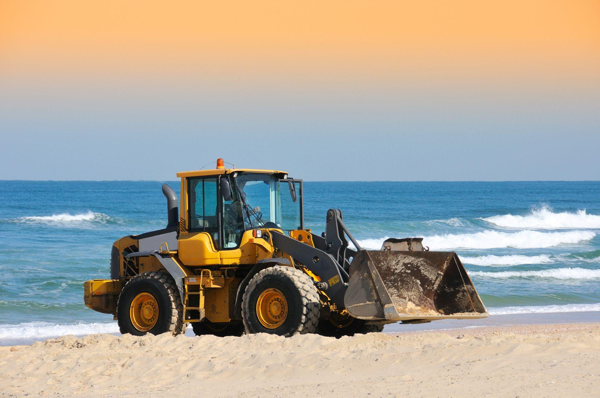 Yellow wheel loader moving material outdoors
